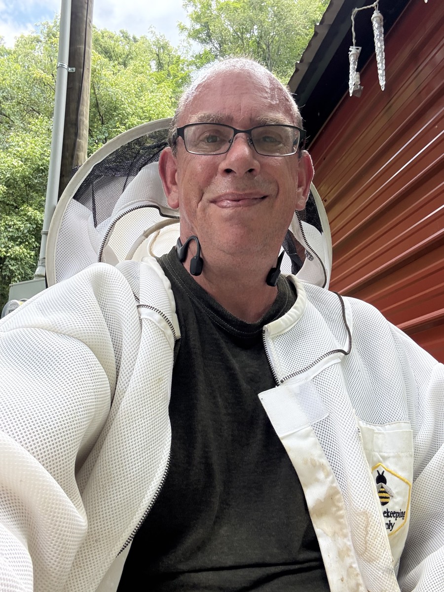 Pa wearing his beekeeping jacket with the veil pulled back